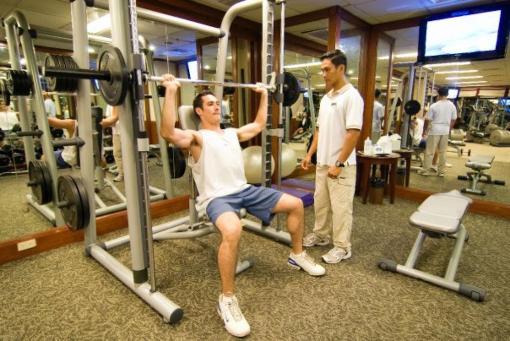 Hotel Marco Polo Davao Exterior foto A personal trainer assisting a client with a weight training exercise